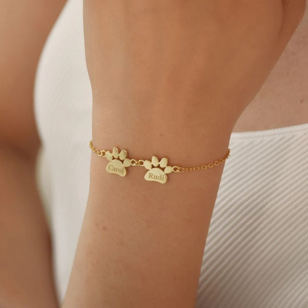 Bracelet Patte de Chien Personnalisé doré avec deux prénoms Carol et Rudi porté au poignet