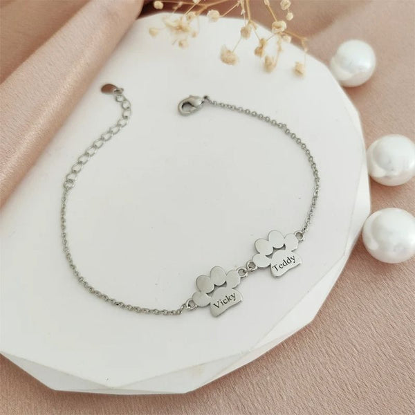Bracelet Patte de Chien Personnalisé argenté avec prénoms Vicky et Teddy sur fond blanc