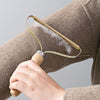 Brosse Anti Poils utilisée sur une manche de manteau en coton