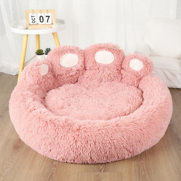 Coussin pour chien en forme de patte rose vide, vu en intérieur avec déco moderne
