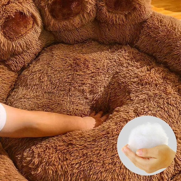 Zoom sur le rembourrage moelleux du Coussin pour chien en forme de patte, main enfoncée dans le coussin