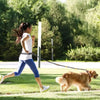 Femme courant dans un parc avec son chien grâce à une laisse mains libres pour chien