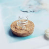 Bague chat argentée posée sur un support naturel - Toutou Love
