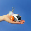 TurboMouse orange dans une main, jouet souris pour chat au format compact et interactif - Toutou Love