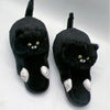 Pantoufles chat noires aux pattes blanches, posées sur fond blanc - Toutou Love
